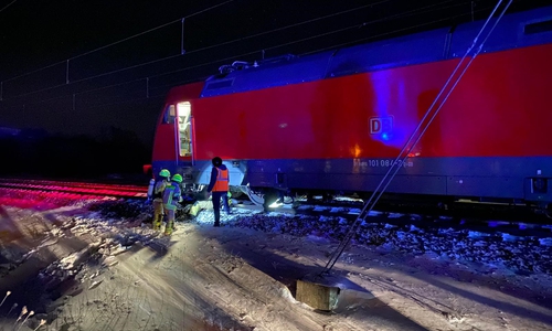 Einsatzkräfte der Feuerwehr inspizieren die heißgelaufene Achse. 