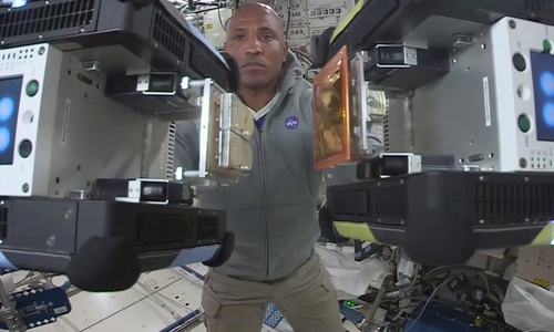 Auf der ISS: US-Astronaut Victor Glover mit zwei Astrobees am 28. Dezember 2020. Astrobee Nr. 1 ist ausgestattet mit einem Gecko-basierten Docking-Mechanismus, Nr. 2 ist ausgestattet mit dem MLI-Material während eines Docking-Manövers. Bildnachweis: IRAS/TU Braunschweig