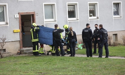 Der Mann wird auf einer Trage aus dem Haus gebracht.