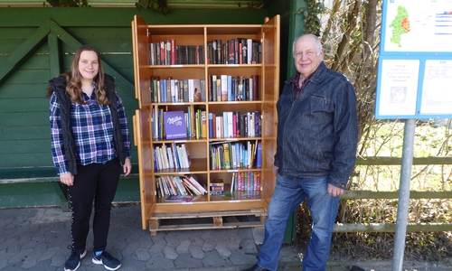 Melanie Klose mit Vater Manfred neben dem Bücherschrank in der Ahmstorfer Bushaltestelle.