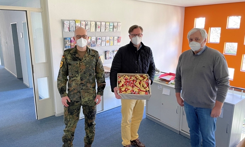 Oberstleutnant Hendrik Staigis (v.l.) und Landrat Dr. Andreas Ebel überreichten Amtsarzt Josef kraft eine süße Stärkung als Dank für die Arbeit über die Feiertage.