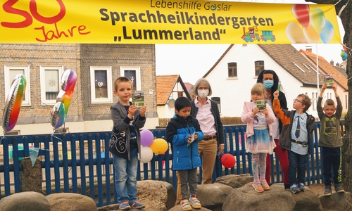 Leiterin Maria Lindemann und Erzieherin Marion Heldt freuen sich mit den Kindern der blauen Gruppe über das Geschenk der Bürgerstiftung: Wanderpässe zum Stempelwandern.