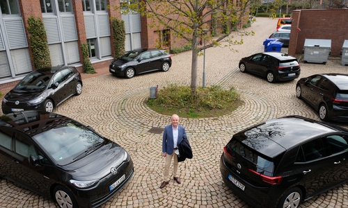 Landrat Thomas Brych inmitten der neuen rein elektrisch betriebenen Dienstwagen der Kreisverwaltung.