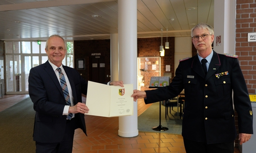 Landrat Thomas Brych gratuliert Kreisbrandmeister Uwe Fricke zur erfolgreichen Wiederwahl.  