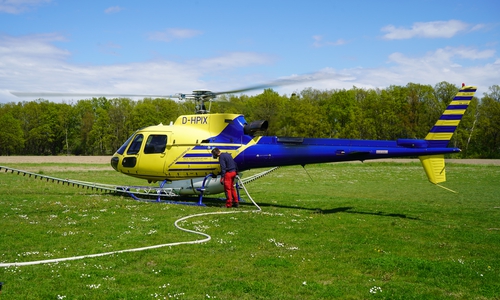Der Hubschrauber mit der Anlage zur Biozidausbringung auf dem Rühener Sportplatz. 