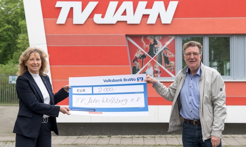 Claudia Kayser, Leiterin der Direktion Wolfsburg der Volksbank BraWo, übergibt die Spende symbolisch an Dirk Räke-Maresté, Geschäftsführer des TV Jahn Wolfsburg.