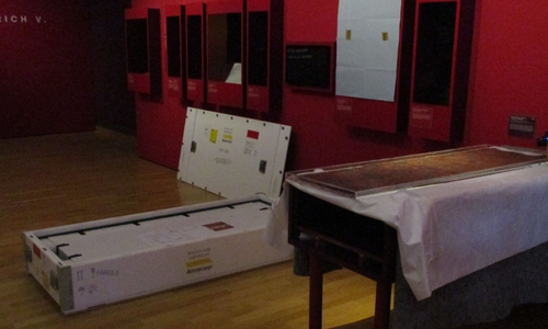 Die Urkunde wird mit dem Schutzbehältnis aus Plexiglas in die vorbereitete Vitrine eingebracht. 