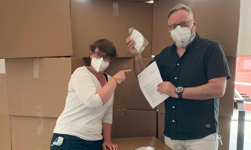 Von links: Katharina Hefenbrock und Thomas Stoch vom DRK nahmen 16 große Kartons mit jeweils 1.000 Masken entgegen.