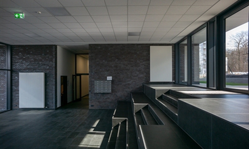  Eingangs- und Foyerbereich des Wohnzwillings. Der Terrassensprung von Norden nach Süden wird geschickt ausgenutzt für eine Tribünensituation mit Sitzstufen.