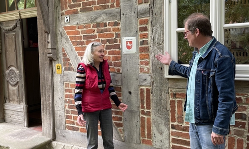 Sabine Jähnert und die neue Denkmalplakette an ihrem Haus in Räbke. 