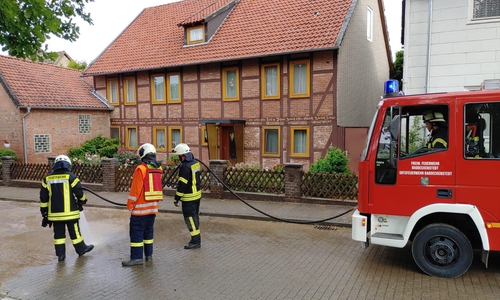 Die Feuerwehr reinigt die Straßen von hinfortgespültem Schlamm. 