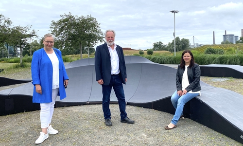 Iris Bothe, Götz Stehr (Leiter Geschäftsbereich Grün) und Katharina Varga (Leiterin Geschäftsbereich Jugend) an dem neuen Pump Track im Allerpark.