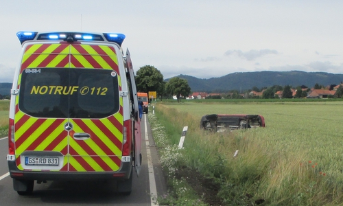 Das Auto landete auf der Seite auf einer Wiese neben der Straße.