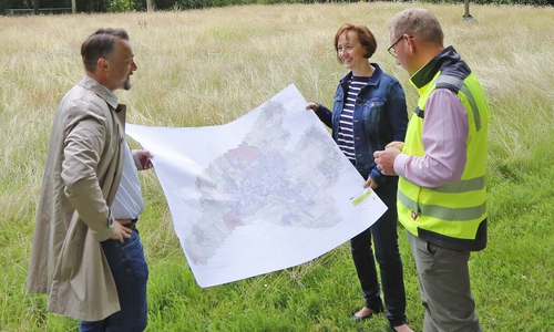 Stadtbaurat Ivica Lukanic (li.), Stiftungsvorstand Manja Puschnerus und Jens Meyer (Abteilungsleiter Grünflächen) vor der Wiese am Jugendfreizeitzentrum.