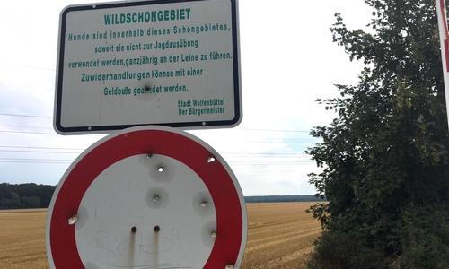 Mit einem Schild wird auf das Schongebiet und den Leinenzwang hingewiesen.