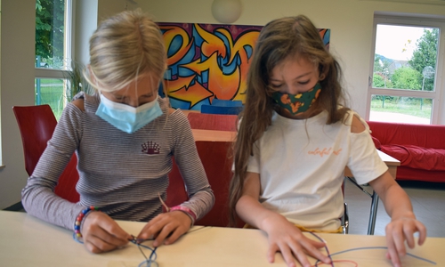 Die achtjährige Maja (links) und die achtjährige Collien knüpfen im KJT-Chillhouse Freundschaftsbänder. 