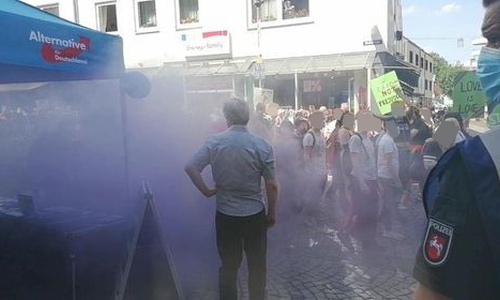 Die lila Rauchbombe hüllte den AfD Stand ein.