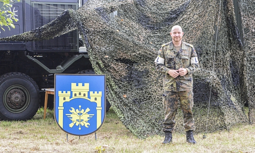 Fregattenkapitän Michael Hinz, Kommandeur Logistikbataillon 171. Neben ihm das Wappen seines Bataillons.
