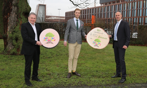 Janis Meyerhof (Mitte) von den Niedersächsischen Landesforsten nimmt die 4.182 Bäume symbolisch von André Bonitzke (r.), Leitung Privatkunden der Volksbank BraWo, im Beisein von Thomas Fast, Botschafter von United Kids Foundations und Vorstandsvorsitzender der Volksbank BraWo Stiftung, entgegen.