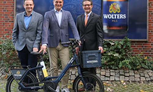 Francesco Perricone (l.), Geschäftsführer Hofbrauhaus Wolters, und Carsten Ueberschär (r.), Leiter der Direktion Braunschweig der Volksbank BraWo, übergeben das eBike in der Wolters-Sonderedition an den glücklichen Gewinner Claas Kirchner (Mitte).