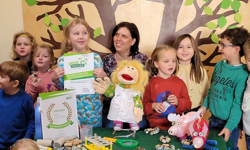 Kita-Mitarbeiterin Michaela Brandt und die Kinder der Kita Hahndorf freuen sich über das Zertifikat zum Haus der kleinen Forscher