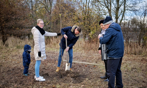 Eine Leinder Familie beim Pflanzen des Baumes für ihren Nachwuchs.