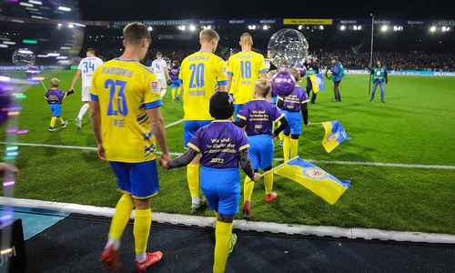 Gemeinsames Einlaufen auf das Spielfeld im Eintracht-Stadion vor mehr als 20.000 Zuschauenden: 14 Fünf- bis Zehnjährige, die einst im Klinikum Braunschweig zu früh zur Welt kamen, machten gemeinsam mit den Fußballprofis auf den Weltfrühgeborenentag aufmerksam.