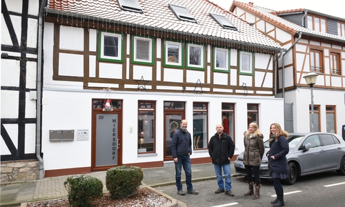 Daniel und Alexandra Wiersdorf (Mitte) vor der sanierten Straßenfassade in der Kampstraße beim Abschlussgespräch mit Rado Velkavrh (links) und Nicole Froberg (rechts) vom Fachbereich Denkmalschutz und Baukultur der Stadt Wolfsburg.