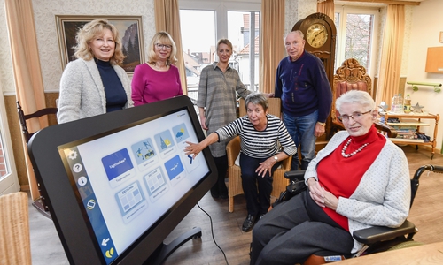Claudia Kayser, Leiterin der Direktion Wolfsburg der Volksbank BraWo, bei der Übergabe des CareTable an Angela Wesche (Heimleitung), Melanie Janzen (Sozialpädagogin), Christa Sturm, Alexander Bohn und Gerda Steininger (Vorsitzende der Bewohnervertretung).