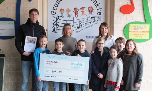 Die Grundschüler präsentieren stolz den Spendenscheck.