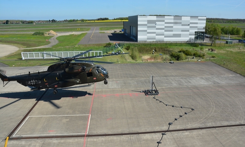 Der He­li­ko­pter CH-53 der Bun­des­wehr flog bei den Ver­su­chen in 2 bis 12 Me­tern Hö­he über dem Roll­feld. Fünf Ka­me­ras nah­men ihn und die Luft­wir­bel an den Ro­to­ren da­bei in den Blick.