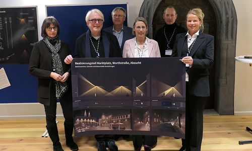 Mit dem Plakat zum Realisierungsteil Marktplatz, Worthstraße, Abzucht in der Hand: Jury-Vorsitzender Prof. Dr. Thomas Römhild (2. v. li.) und Oberbürgermeisterin Urte Schwerdtner (re.) im Kreis weiterer Jury-Mitglieder.