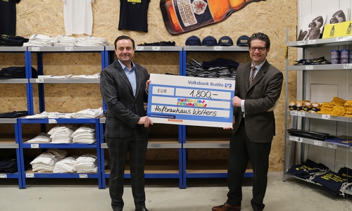 Francesco Perricone (li.), Geschäftsführer des Hofbrauhaus Wolters, übergibt die Spende stilecht im Wolters Fanshop an Carsten Ueberschär, Botschafter von United Kids Foundations und Leitung der Direktion Braunschweig.