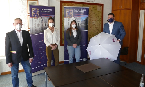 Symbolische Schirmübergabe: Die Regionalinitiative „Südheide genießen!“ – Vertreten durch Olaf Müller und Imke Wolter (aus dem Vorstand Regionalinitiative) und Geschäftsführerin Rebekka Schütte (v. l.) – begrüßen Landrat Tobias Heilmann als neuen Schirmherren.