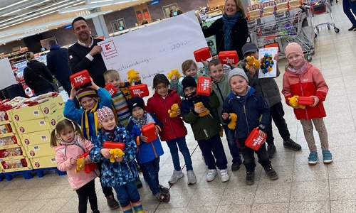 Bei der Spendenübergabe dabei: Kindergarten-Leiterin Christine Scherf mit Kindern der Einrichtung sowie Kaufland-Hausleiter Mario Friedrich. 
