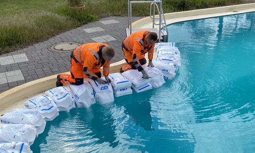 Mitarbeiter des Betriebshofes beim Einfüllen des für Grasleben charakteristischen Salzes in das Becken des Freizeitbades. 