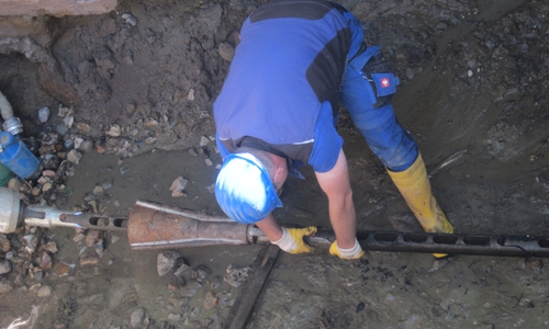 Das vorbereitete Kunststoffrohr wird von rechts ins bestehende Rohr eingezogen und verschwindet im Erdreich. Die neue Leitung wird zwischen zwei Baugruben eingezogen. Dieses grabenlose Verfahren wird nun auch in Hohenhameln für eine Maßnahme im Trinkwassernetz genutzt. Archivbild