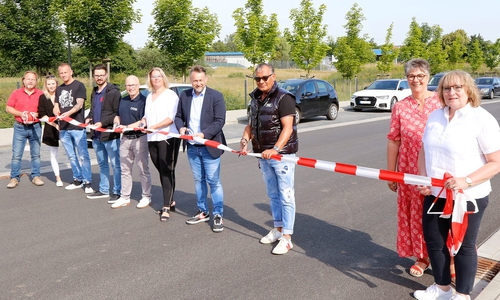 Bürgermeister Ivica Lukanic (4.v.r.) durchschnitt gemeinsam mit Vertretern der anliegenden Firmen und Uwe Watolla (3.v.r.) das Flatterband als Zeichen der offiziellen Freigabe der fertiggestellten Heinrich-Eberhardt-Straße im Gewerbegebiet West.