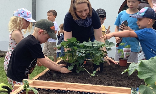 Projektleiterin Mireille Müller mit den Kids der Kita bei der Hochbeetbepflanzung. Auch Eltern halfen tatkräftig mit.