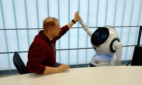  Eine Zusammenarbeit der besonderen Art: Gerret Lose, wissenschaftlicher Mitarbeiter im Forschungsprojekt der Ostfalia, mit dem humanoiden Roboter CRUZR.