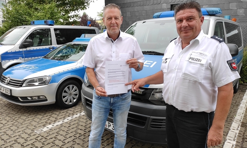 Erster Kriminalhauptkommissar Andreas Twardowski (links) und Polizeipressesprecher Frank Oppermann zeigen den Handzettel, der jetzt an Anwohner der Innenstadt verteilt wird.