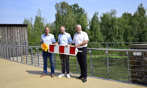 Michael Truthe (Geschäftsbereich Straßenbau und Projektkoordination), Oberbürgermeister Dennis Weilmann und Oliver Iversen, Leiter des Geschäftsbereichs Straßenbau und Projektkoordination, entfernen symbolisch die letzte Absperrbake auf der Brücke "Altes Wehr".