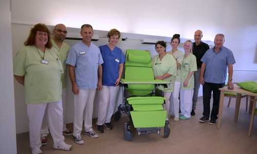 Die Stationsmitarbeiter mit dem neuen Stuhl.