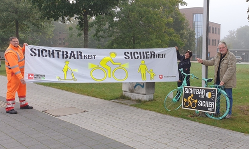 Alexander Weis vom SRB, Kahtrin Lacey von der Polizei und Markus Müller von der Verkehrswacht (v.l.n.r.) präsentieren die neuen Spannbänder und Fahrradinstallationen zum Thema Sichtbarkeit und Sicherheit.