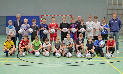 Christiane Döring vom Weltladen (links), daneben Matthias Knoche-Herwig, Sprecher der Steuerungsgruppe Fairtrade-Stadt und die C-Jugend des SV Halchter.