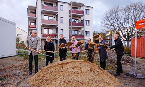 Gute Laune aller Beteiligten beim Spatenstich der Neuland im Schlesierweg in Wolfsburg für das nächste „Wohnen für Alle“-Projekt. Im Hintergrund sind die bereits voll vermieteten Gebäude aus den ersten beiden Bauabschnitten zu sehen.