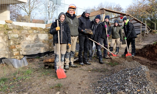 Die sechs jungen Leute bauen an der Rekonstruktion der Mauer.