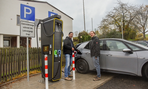 Bürgermeister Michael Waßmann und Projektleiter Pascal Geißler nehmen die Ladesäule in Betrieb.