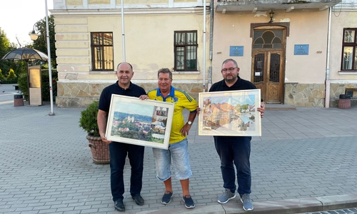 Besuch des 5. Hilfstransportes (August 2022) in Solotschiw gefahren sind. Peter Voß (Vorsitzender PVS, Mitte) und Jan Fricke (Vereinsmitgleid und stellv. Landrat) übergeben Bilder aus und von der Partnerstadt Schöningen an Solotschiws Bürgermeister Íhor Grynkiv vor dem Rathaus in Solotschiw.