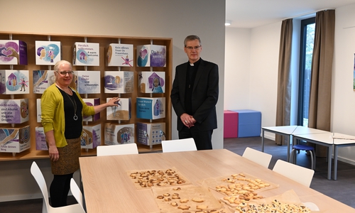 Herzstück des Frauenhauses ist der Gemeinschaftsraum. Hier werden gemeinsam Plätzchen gebacken, wird gekocht, gespielt und gemeinsam geredet. Auf dem Foto: Frauenhausleiterin Ulla Evers und Bischof Dr. Heiner Wilmer SCJ vor der freundlich gestalteten Hausordnung.